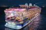 Crucero de lujo iluminado de noche con zona de casino y mesas de juego.